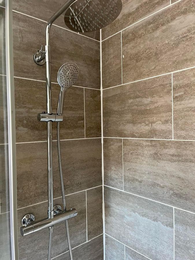 Rainfall shower on stone-effect tiles