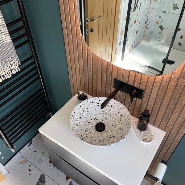 Terrazzo basin on a floating vanity against a teal wall