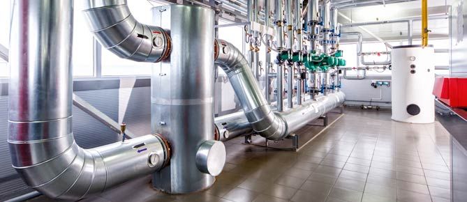 Insulated pipework and pump set beside a hot water cylinder
