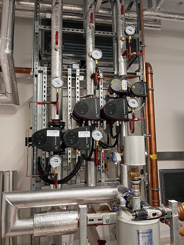 Circulating pumps and pressure gauges on a plant room riser
