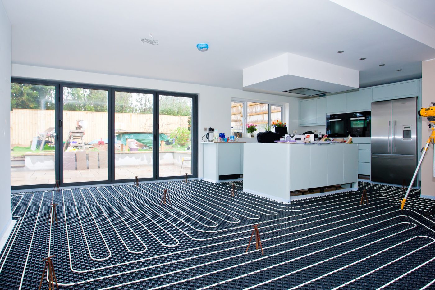Heating pipework being laid across the floor of a new kitchen extension