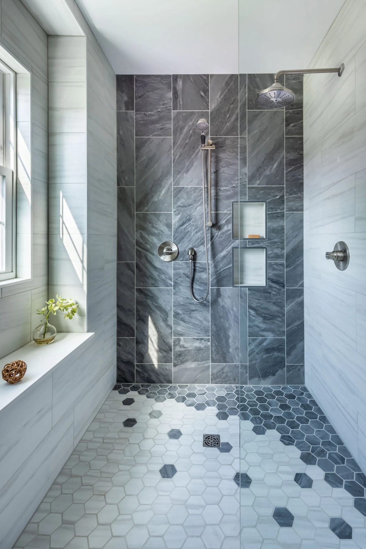 Walk-in shower with grey marble-effect tiles and a hexagon tiled floor