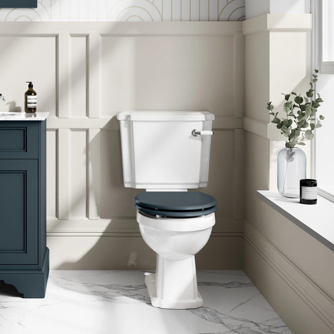 Traditional close-coupled toilet with a dark wooden seat in a panelled bathroom